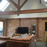 the-green-oak-building-company-oak-framed-interior-with-exposed-roof-structure-red-brick-infill-panels-and-oak-joinery